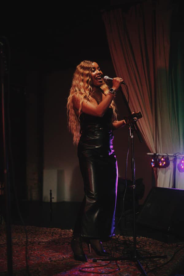 April performing live on stage with microphone